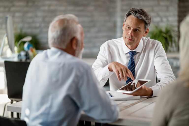 A man in a business suit converses with another man, both engaged in a professional discussion.