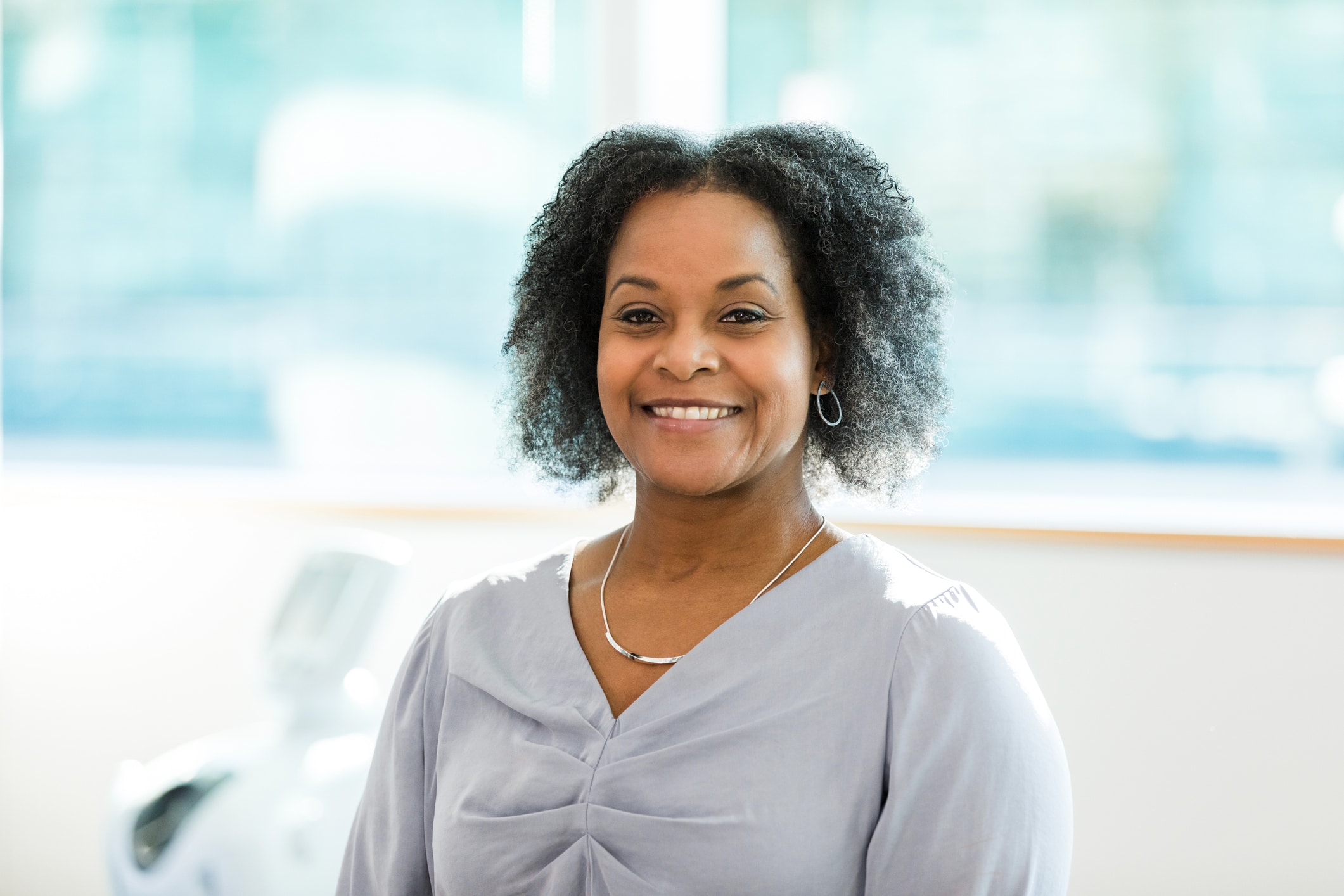 The mid adult businesswoman smiles broadly for the camera.