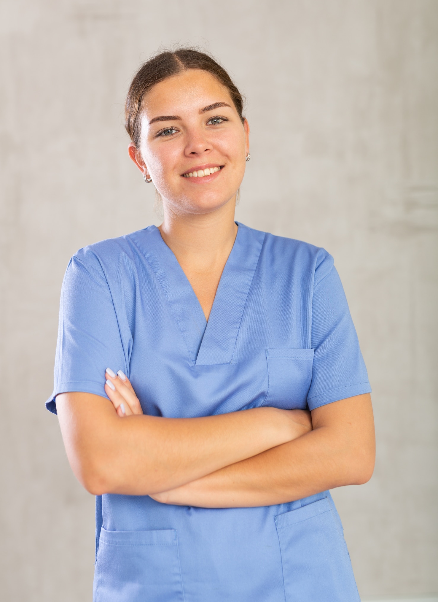 Portrait of young female medic in medical uniform posing in studio
