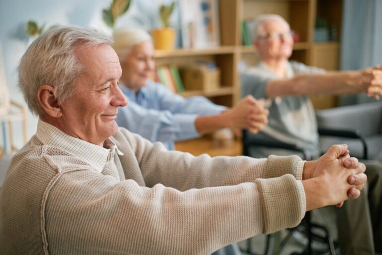 Senior individuals engaging in light exercises together in a cozy living room setting.