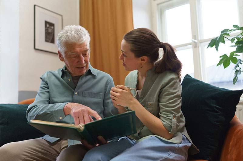 Senior man with his grandaughter reading book.